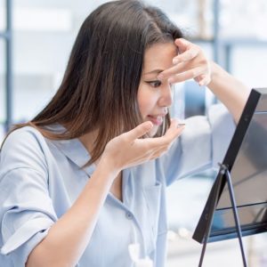 woman putting on contact lens